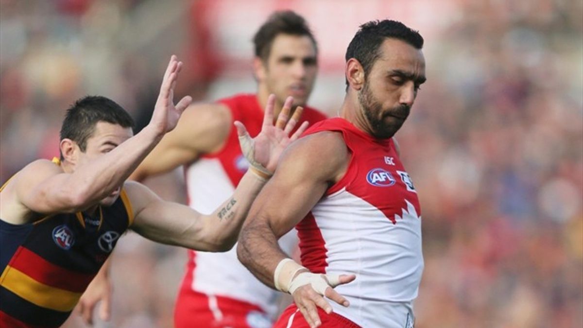 Adam Goodes of the Sydney Swans gets a running kick away before being tackled by Ian Callinan of the Adelaide Crows (AAP)