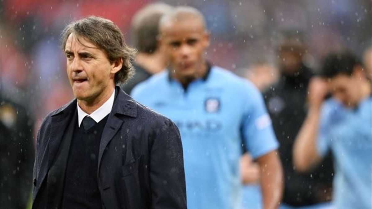 Manager Roberto Mancini of Manchester City and Vincent Kompany look dejected in defeat after the FA Cup with Budweiser Final between Manchester City and Wigan Athletic at Wembley Stadium on May 11, 2013