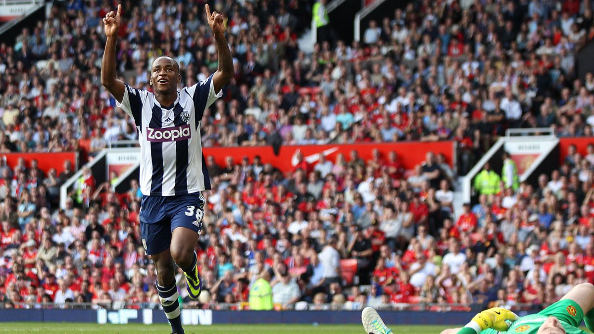 West Bromwich Albion's Saido Berahino celebrates scoring the 2nd goal against Manchester United while David De Gea lies flat out.