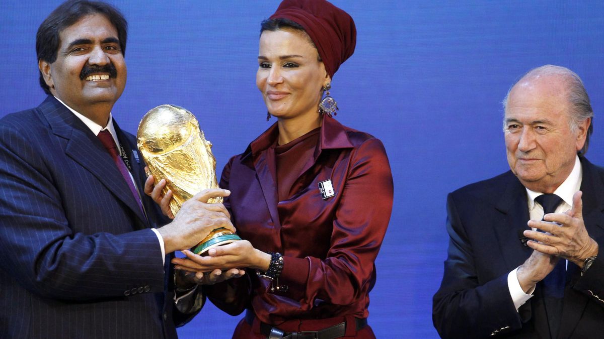 Sheikha Moza Bint Nasser al-Misnad, wife of Qatar's Emir Sheikh Hamad bin Khalifa al Thani (L), holds a copy of the World Cup he received from FIFA President Sepp Blatter (R) after the announcement that Qatar is going to be host nation for the FIFA World
