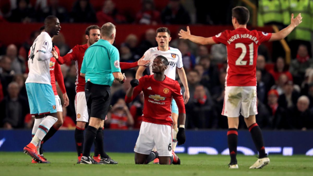 Manchester United's Paul Pogba is booked for diving by referee Jon Moss