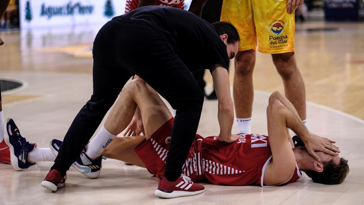 El jugador del Baxi Manresa Guillem Jou se lamenta en el suelo mientras es atendido por el médico de su equipo tras lesionarse durante el partido de la decimotercera jornada de la Liga Endesa contra el Gran Canaria