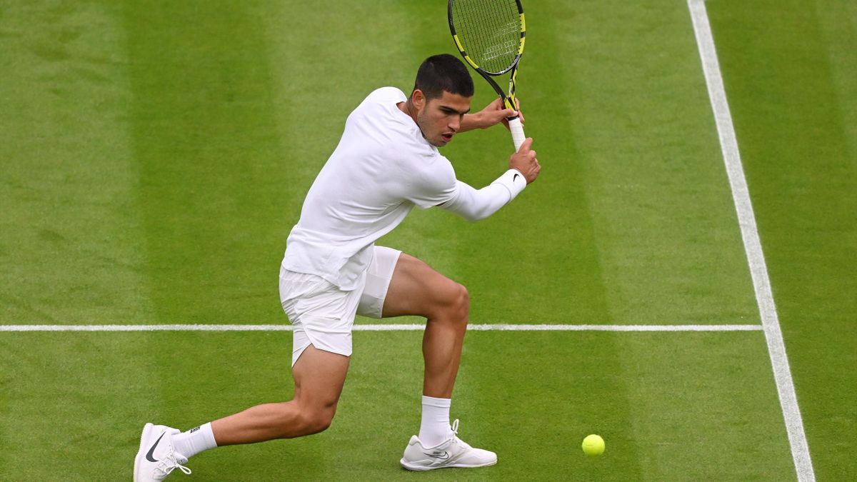 Carlos Alcaraz of Spain plays a backhand against Jan-Lennard Struff of Germany during the Men's Singles First Round match during Day One of The Championships Wimbledon 2022 at All England Lawn Tennis and Croquet Club on June 27, 2022 in London, England