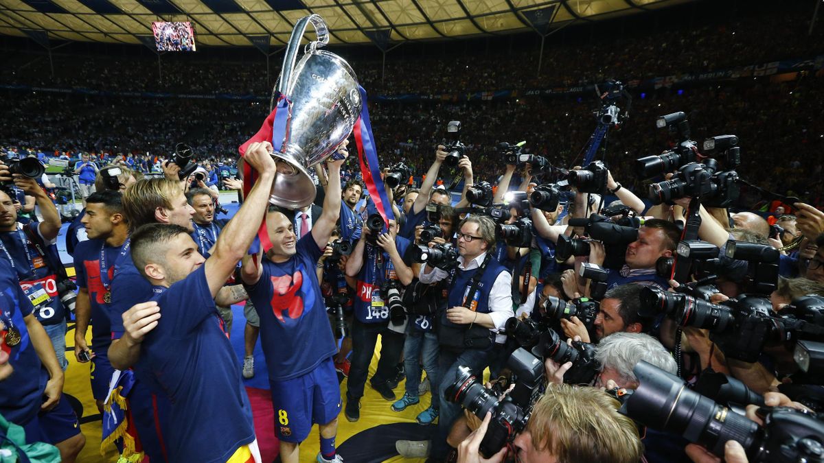 Barcelona's Andres Iniesta celebrates with the trophy and team mates after winning the UEFA Champions League