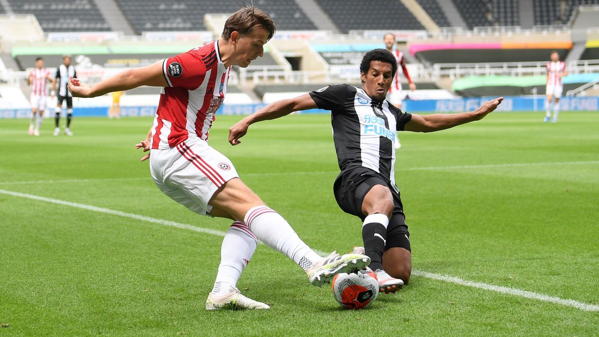 Sheffield United's Norwegian midfielder Sander Berge (L) crosses the ball in front of Newcastle United's English midfielder Isaac Hayden (R) during the English Premier League football match between Newcastle United and Sheffield United at St James' Park i