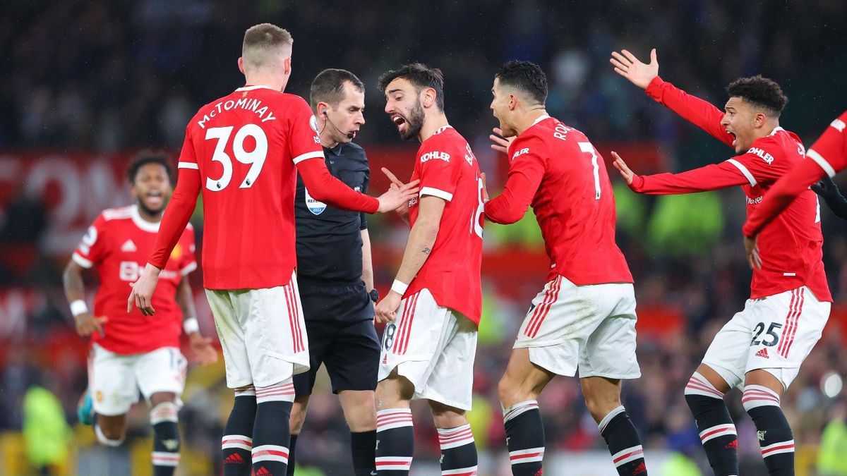 Manchester United players surrounds the referee during the Premier League match between Manchester United and Brighton & Hove Albion at Old Trafford on February 15, 2022 in Manchester, England.