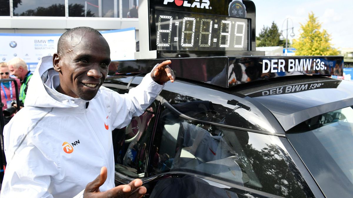 Kenya's Eliud Kipchoge stands next to a clock displaying his time after winning the Berlin Marathon setting a new world record with 2h01m39s