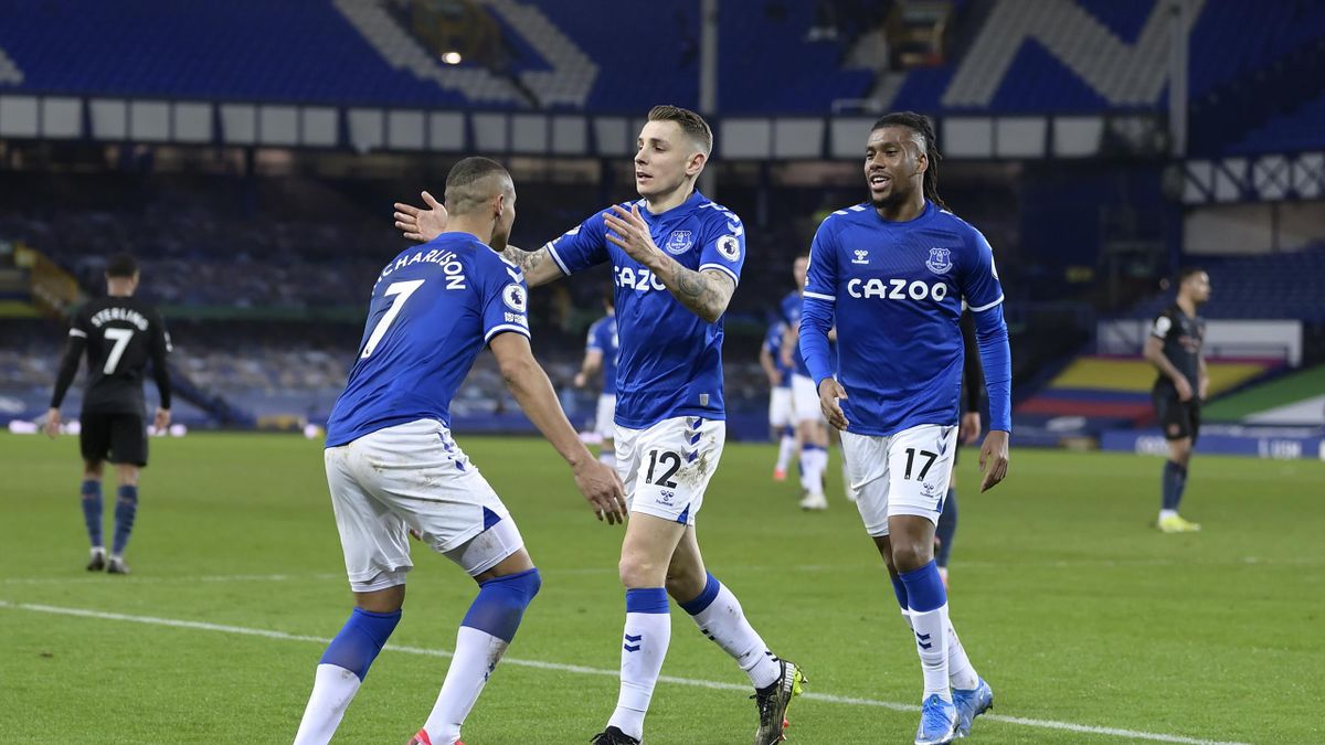 : Richarlison of Everton (L) celebrates his goal with Alex Iwobi (R) and Lucas Digne during the Premier League match between Everton and Manchester City at Goodison Park on February 17 2021 in Liverpool, England.