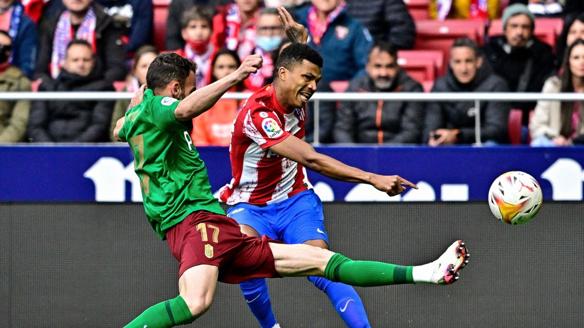 Granada's Spanish defender Quini (L) fights for the ball with Atletico Madrid's Mozambican defender Reinildo during the Spanish League football match between Club Atletico de Madrid and Granada FC at the Wanda Metropolitano stadium in Madrid on April 20,