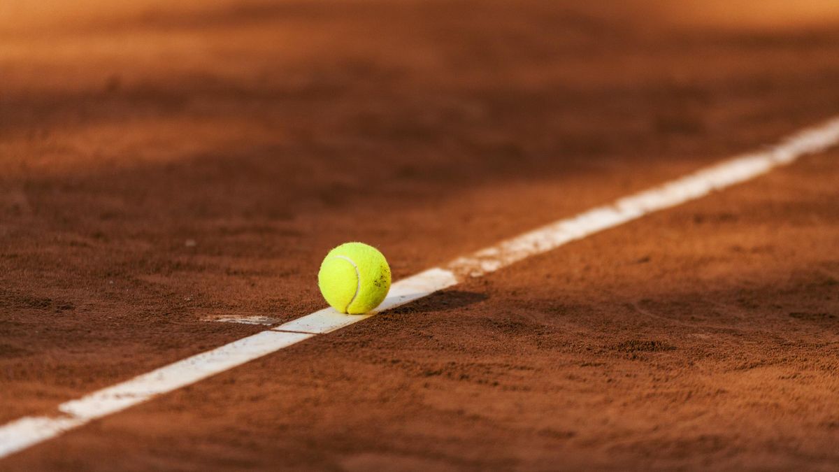 Tennis ball hitting the line on clay court