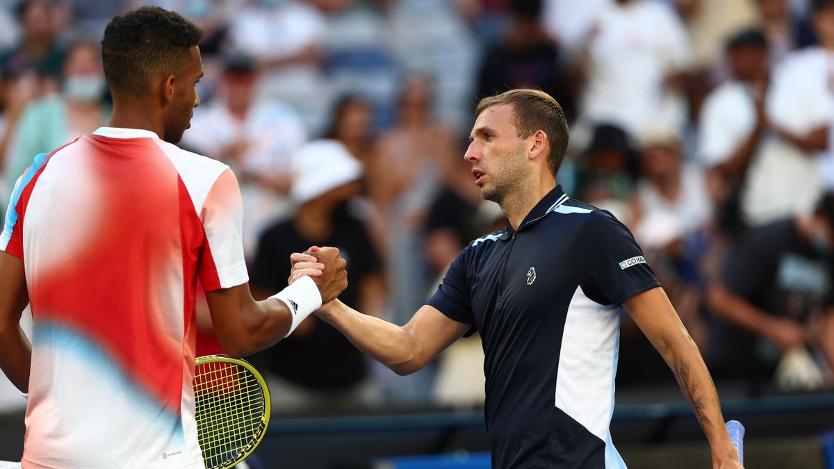 Felix Auger-Aliassime and Dan Evans clasp hands at the net after the match