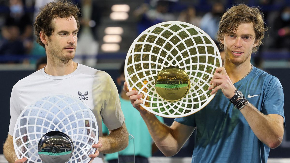 Andrey Rublev of Russia holds up his trophy alongside second-place winner Andy Murray of Britain during the awards ceremony after the final match of the Mubadala World Tennis Championship in the Gulf emirate of Abu Dhabi on December 18, 2021.