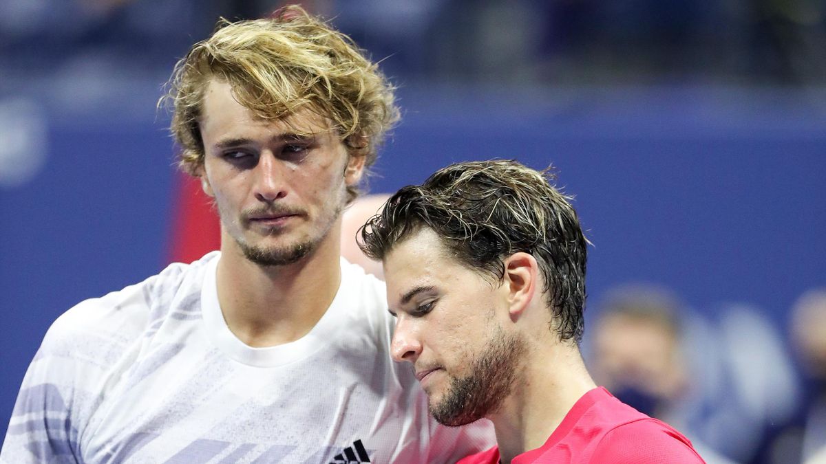 Dominic Thiem (R) of Austria holds with championship trophy as he embraces Alexander Zverev (L) of Germany after their Men's Singles final match on Day Fourteen of the 2020 US Open at the USTA Billie Jean King National Tennis Center