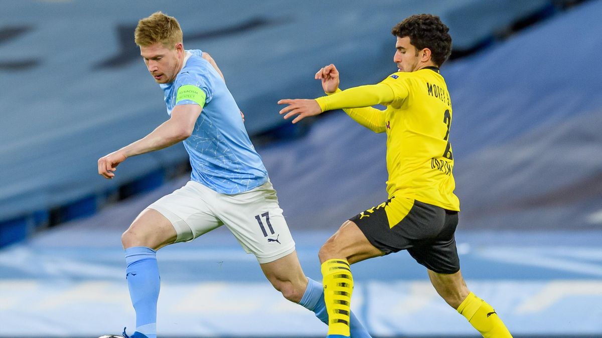 Kevin De Bruyne of Manchester City and Mateu Morey of Borussia Dortmund battle for the ball during the UEFA Champions League Quarter Final match between Manchester City and Borussia Dortmund at Manchester City Football Academy on April 6, 2021 in Manchest