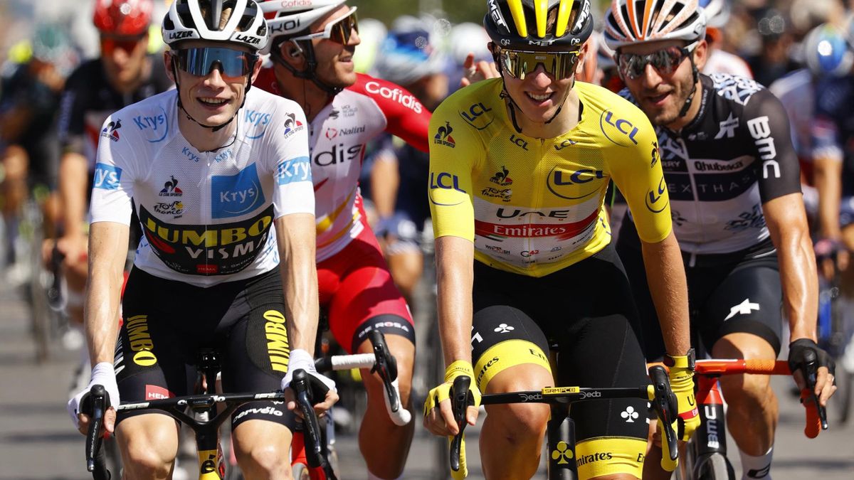 Team UAE Emirates' Tadej Pogacar of Slovenia wearing the overall leader's yellow jersey (R) rides next to Team Jumbo Visma's Jonas Vingegaard of Denmark wearing the best young's white jersey during the 21th and last stage of the 108th edition of the Tour