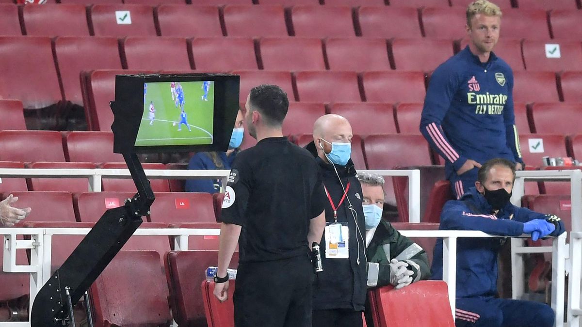 Match Referee, Chris Kavanagh checks a VAR decision on screen ahead of showing Eddie Nketiah of Arsenal (not pictured) a red card during the Premier League match between Arsenal FC and Leicester City at Emirates Stadium on July 07, 2020 in London, England