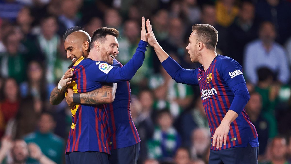 Lionel Messi of FC Barcelona celebrates with his teammates Arturo Vidal and Arthur Melo of FC Barcelona after scoring his team's second goal during the La Liga match between Real Betis Balompie and FC Barcelona at Estadio Benito Villamarin on March 17, 20