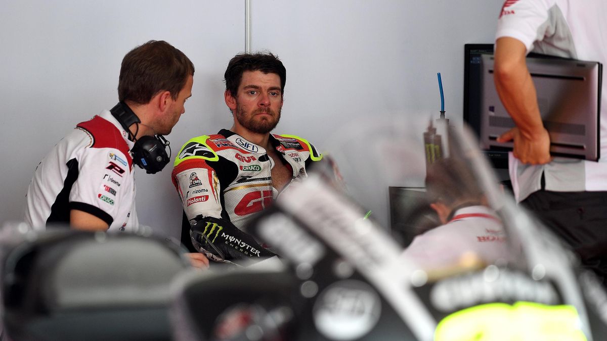 Cal Crutchlow (C) sits in the team's garage during the first day of 2017 MotoGP pre-season test at the Sepang International Circuit on January 30, 2017