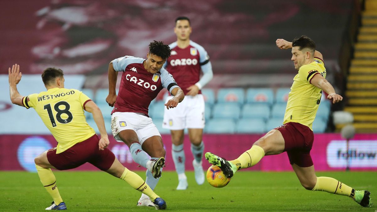 Ollie Watkins of Aston Villa shoots whilst being closed down by Ashley Westwood (l) and James Tarkowski of Burnley during the Premier League match between Aston Villa and Burnley at Villa Park