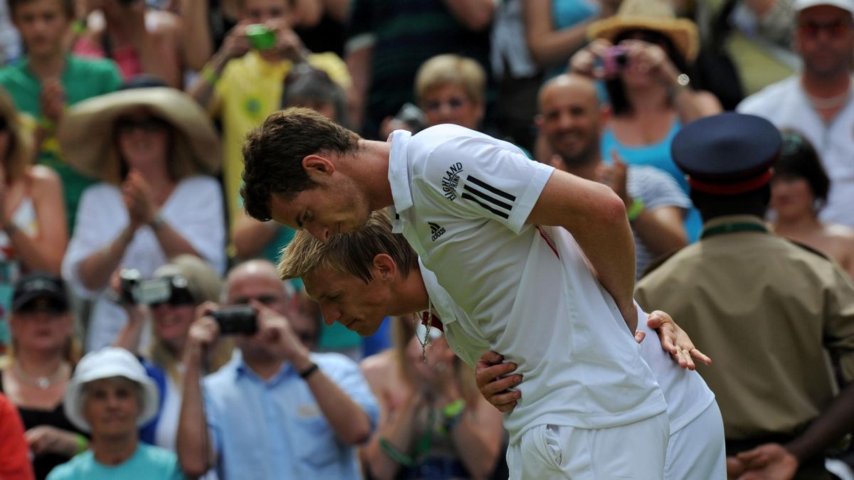 Britain's Andy Murray (front) and Finland's Jarkko Nieminen bow to Britain's Queen Elizabeth II, after Murray won their match, on the fourth day of the Wimbledon Tennis Championships, at the All England Lawn Tennis Club