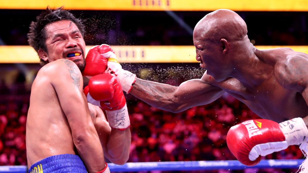 Manny Pacquiao (L) takes a punch from Yordenis Ugas during their WBA welterweight title fight at T-Mobile Arena,  Las Vegas, Nevada, August 21, 2021