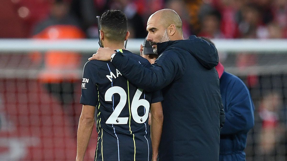 Manchester City's Spanish manager Pep Guardiola talks with Manchester City's Algerian midfielder Riyad Mahrez as they leave the pitch following the English Premier League football match between Liverpool and Manchester City at Anfield in Liverpool, north