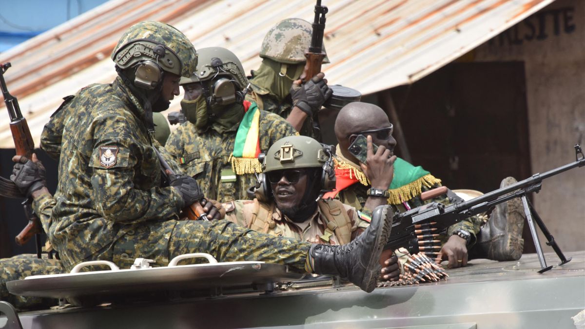 Members of Guinea's armed forces celebrate after the arrest of Guinea's president, Alpha Conde, in a coup d'etat in Conakry on September 5, 2021. - Guinean special forces seized power in a coup on September 5, arresting the president and imposing an indef