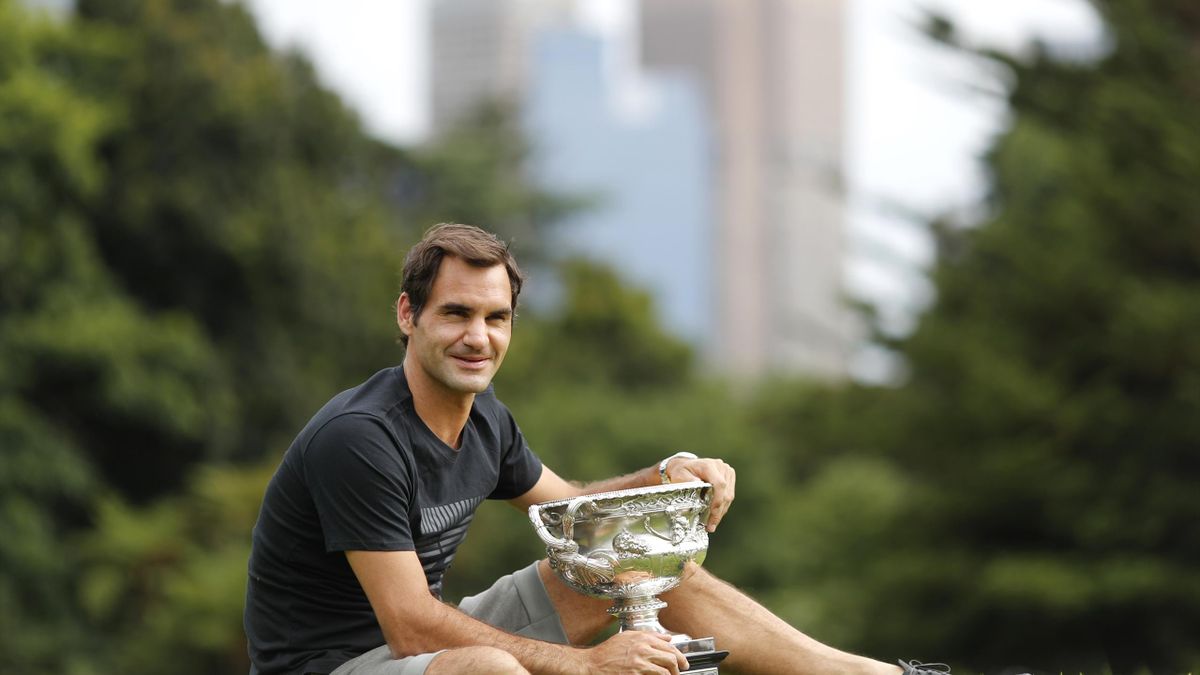 Roger Federer poses with the trophy the morning after his Australian Open triumph (Ng Han Guan/AP)