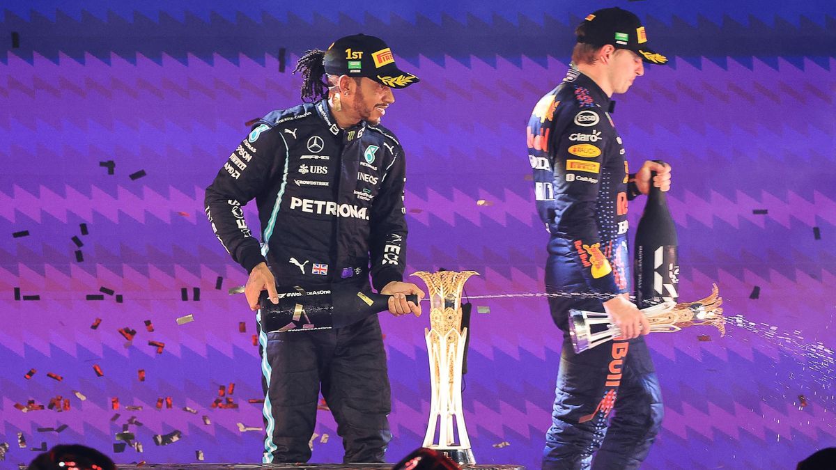 Lewis Hamilton sul podio di Jeddah con lo spumante mentre Max Verstappen si incammina mesto dopo la premiazione, F1, Getty Images
