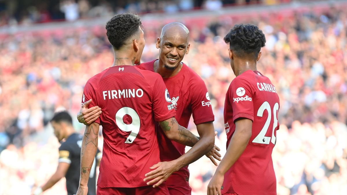 Roberto Firmino of Liverpool celebrates with teammates Fabinho and Fabio Carvalho after scoring their team's seventh goal during the Premier League match between Liverpool FC and AFC Bournemouth at Anfield