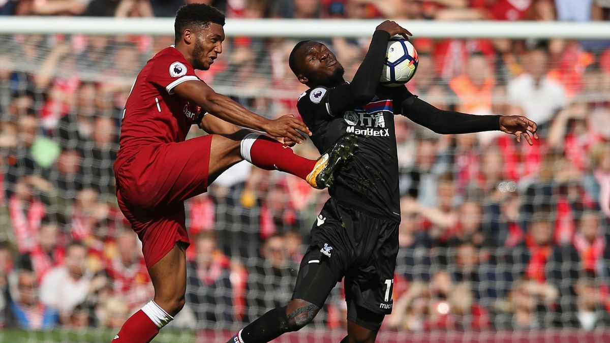 Christian Benteke of Crystal Palace handles the ball while under pressure from Joe Gomez of Liverpool during the Premier League match between Liverpool and Crystal Palace at Anfield on August 19, 2017 in Liverpool, England.