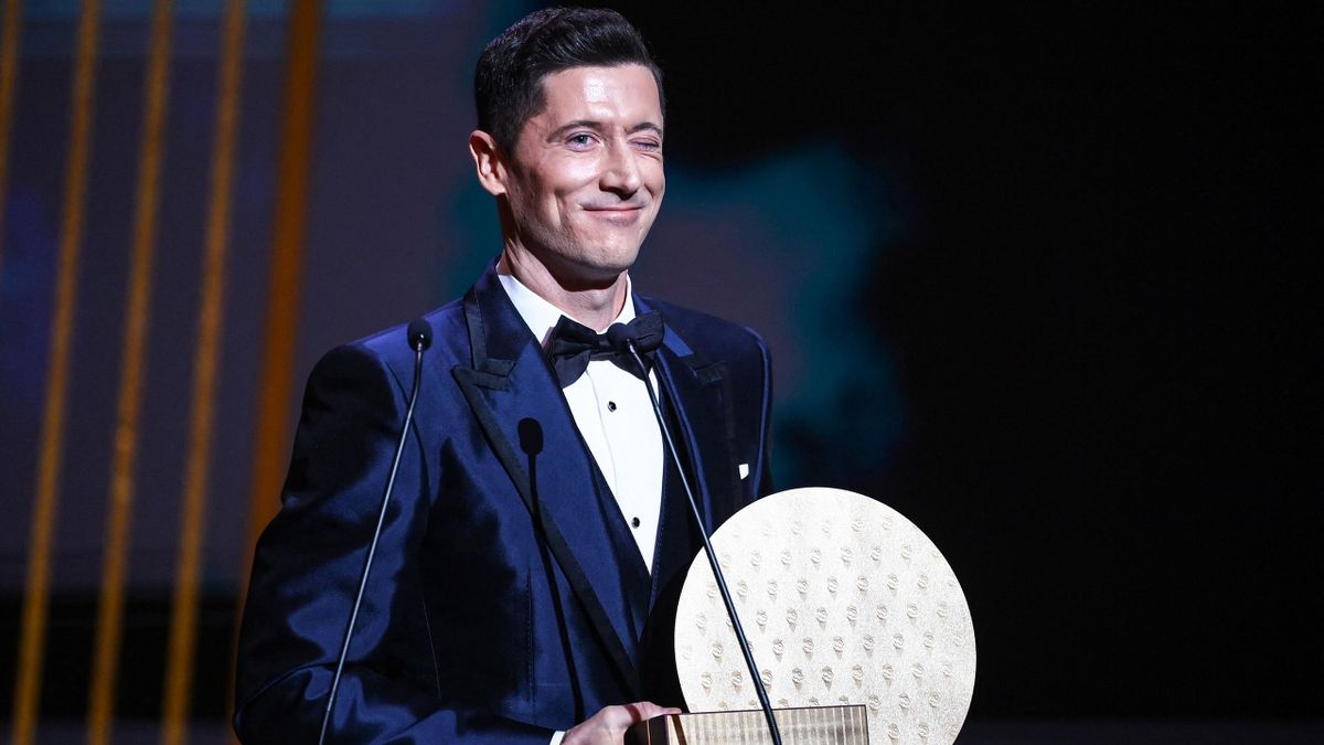 Robert Lewandowski reacts on stage after being awarded the Striker of the Year award the 2021 Ballon d'Or France Football award ceremony
