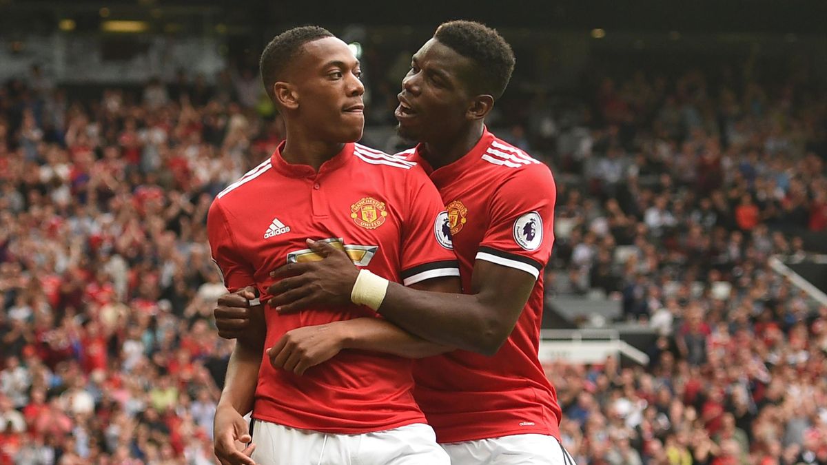 Manchester United's French striker Anthony Martial (L) celebrates with Manchester United's French midfielder Paul Pogba after scoring their third goal during the English Premier League football match between Manchester United and West Ham United at Old Tr
