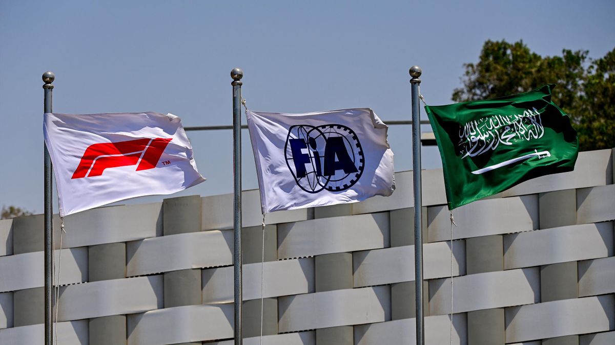 The flags of the Formula One (L), the Federation Internationale de l'Automobile (C) and Saudi Arabia (R) wave ahead of the third practice session ahead of the 2022 Saudi Arabia Formula One Grand Prix at the Jeddah Corniche Circuit on March 26, 2022.