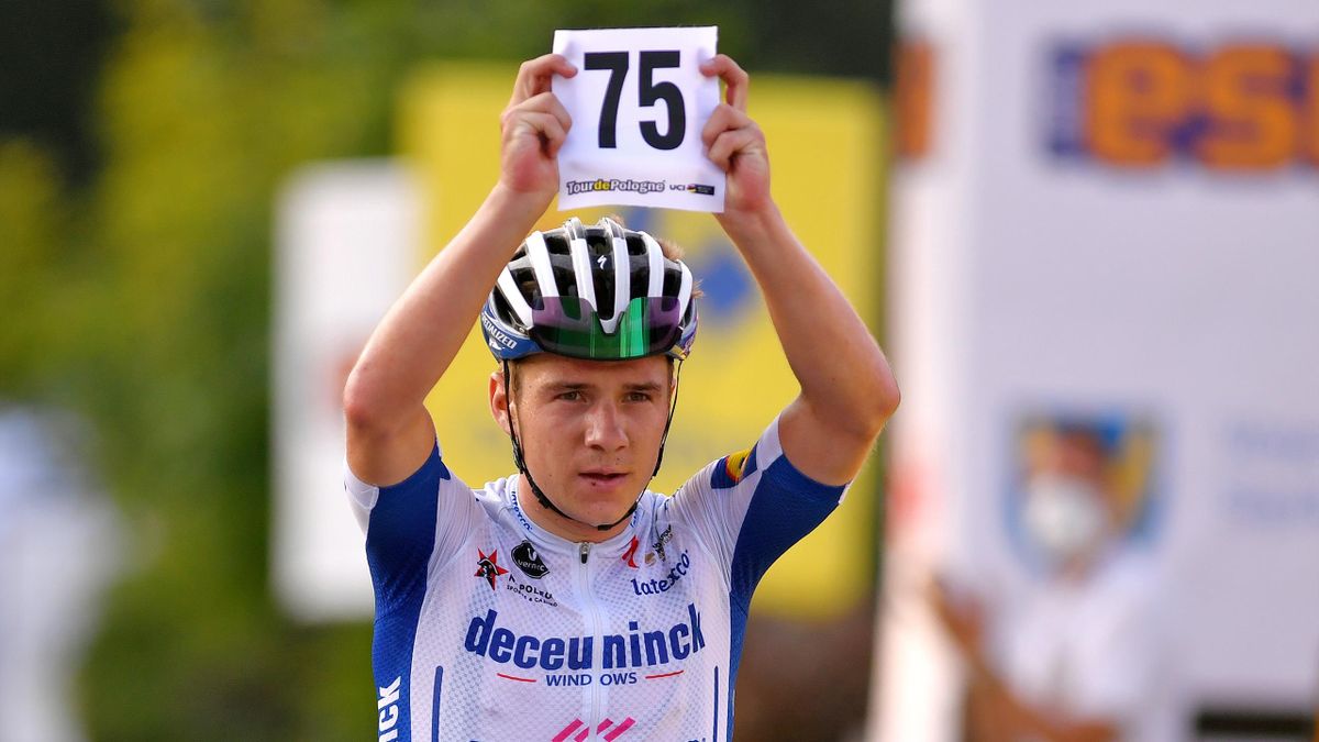 Remco Evenepoel holding up the race number of teammate Fabio Jakobsen as he crosses the finish line in August 2020