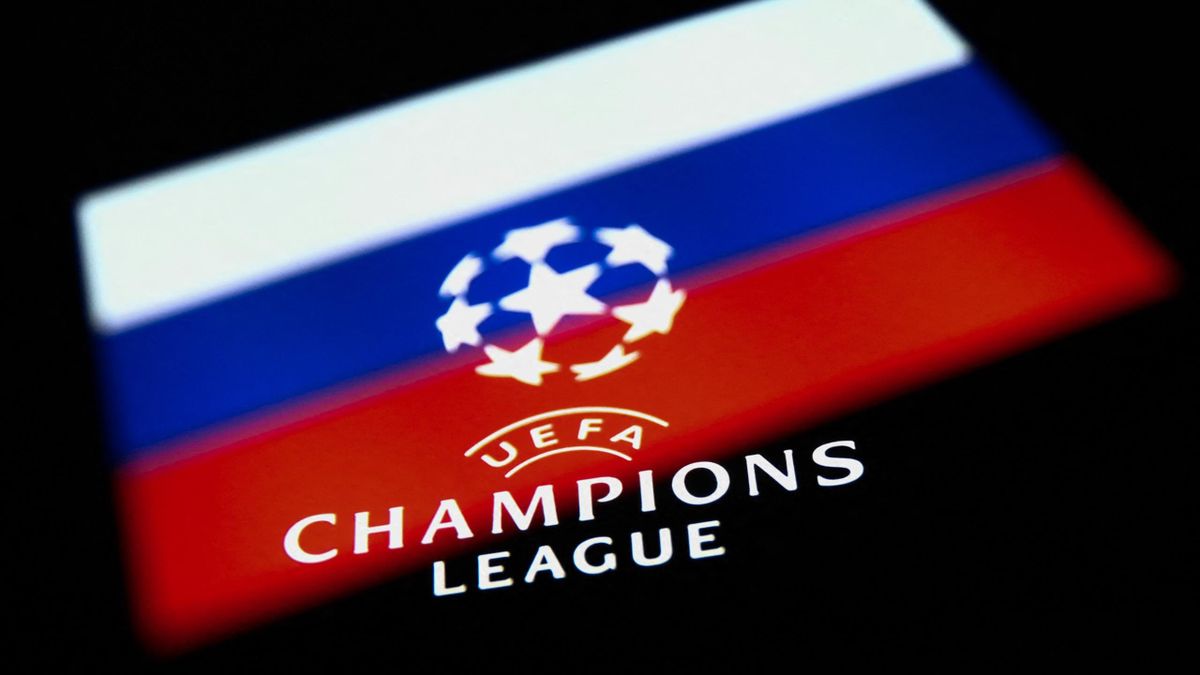 UEFA Champions League logo displayed on a phone screen and Russian flag displayed on a phone screen are seen in this multiple exposure illustration photo taken in Krakow, Poland on February 24, 2022.