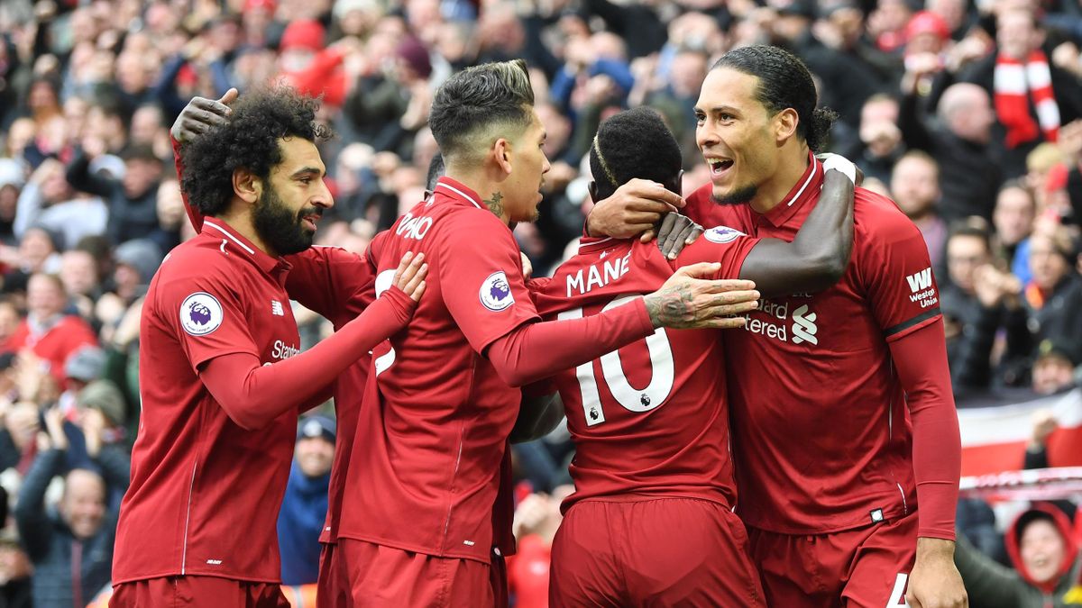 Sadio Mane of Liverpool (10) celebrates after scoring his team's first goal with Virgil van Dijk, Roberto Firmino and Mohamed Salah during the Premier League match between Liverpool FC and Chelsea FC at Anfield on April 14, 2019 in Liverpool, United Kingd