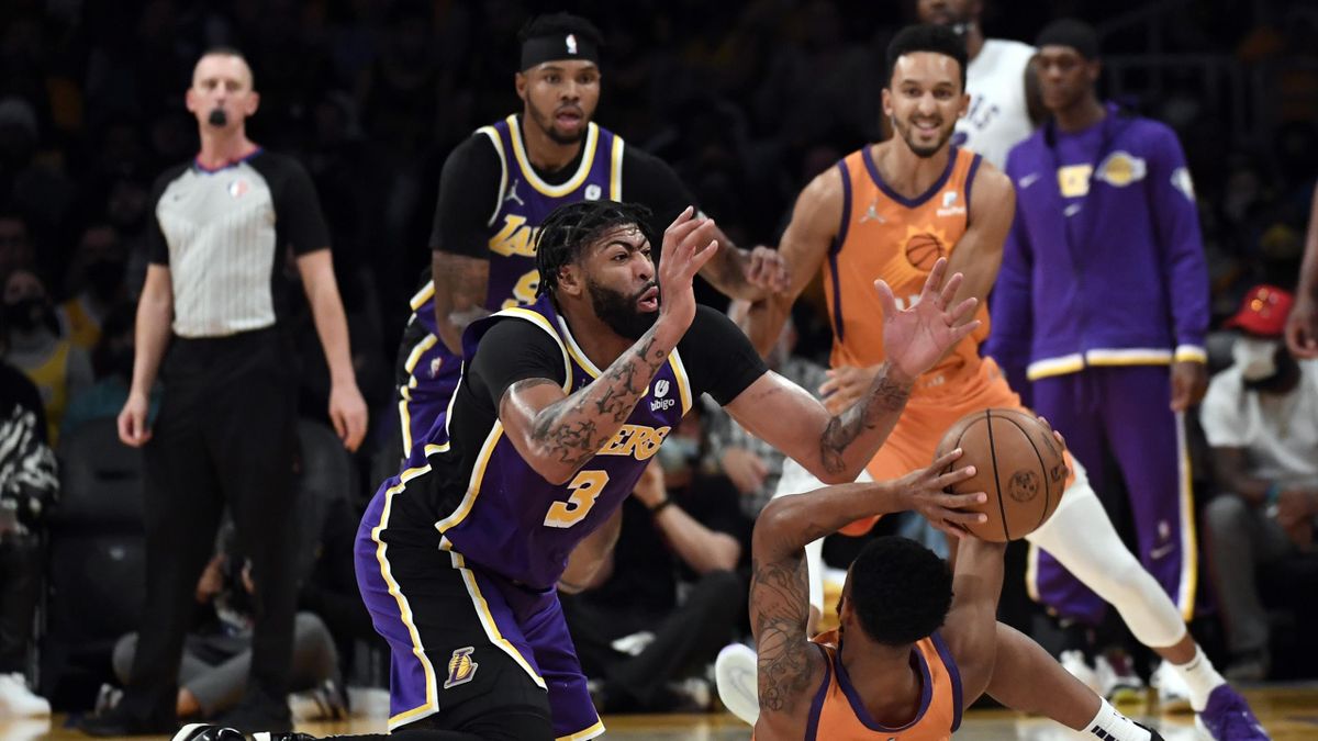 LOS ANGELES, CA - OCTOBER 22: Anthony Davis #3 of the Los Angeles Lakers battle for the ball with Cameron Payne #15 of the Phoenix Suns during the first half of the game at Staples Center on October 22, 2021 in Los Angeles, California. NOTE TO USER: User