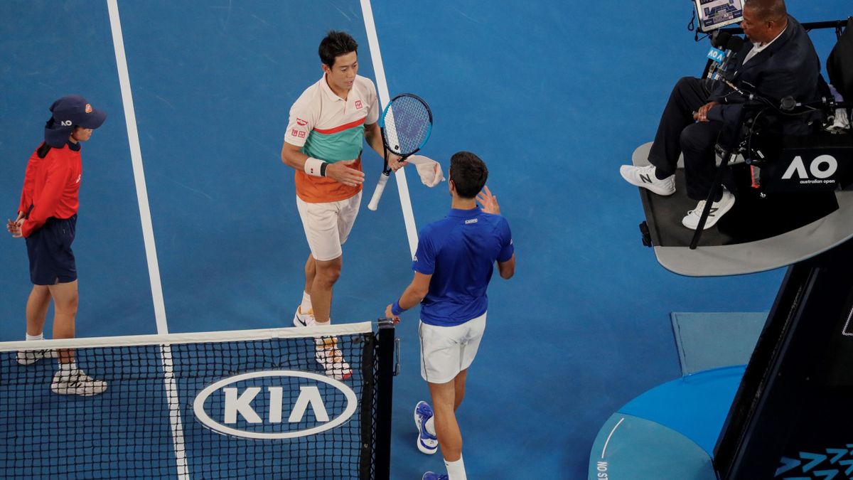 Japan's Kei Nishikori (C) embraces as he leaves the court after retiring from his men's singles quarter-final match against Serbia's Novak Djokovic (L)