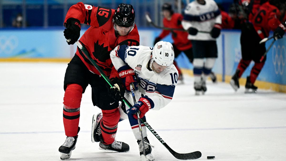 Adam Tambellini und Matty Beniers beim Kampf um den Puck der Vorundenpartie Kanada gegen USA des Olympia Eishockey-Turniers in Peking 2022
