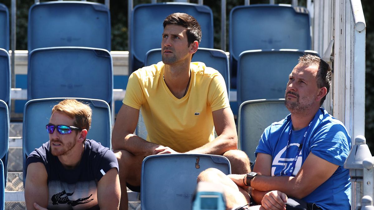 Novak Djokovic of Serbia (C) watches the Men's Singles first round match between Filip Krajinovic of Serbia