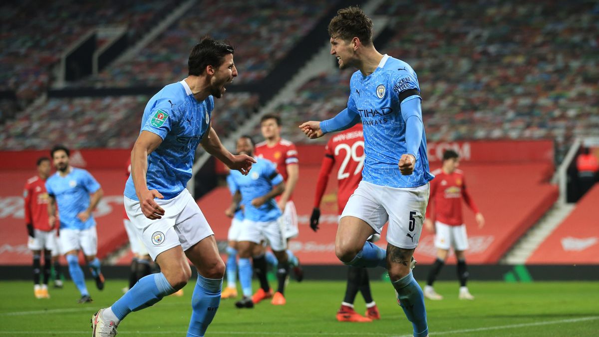 John Stones of Manchester City celebrates scoring the opening goal with Ruben Dias during the Carabao Cup Semi Final match between Manchester United and Manchester City at Old Trafford on January 6, 2021 in Manchester, England