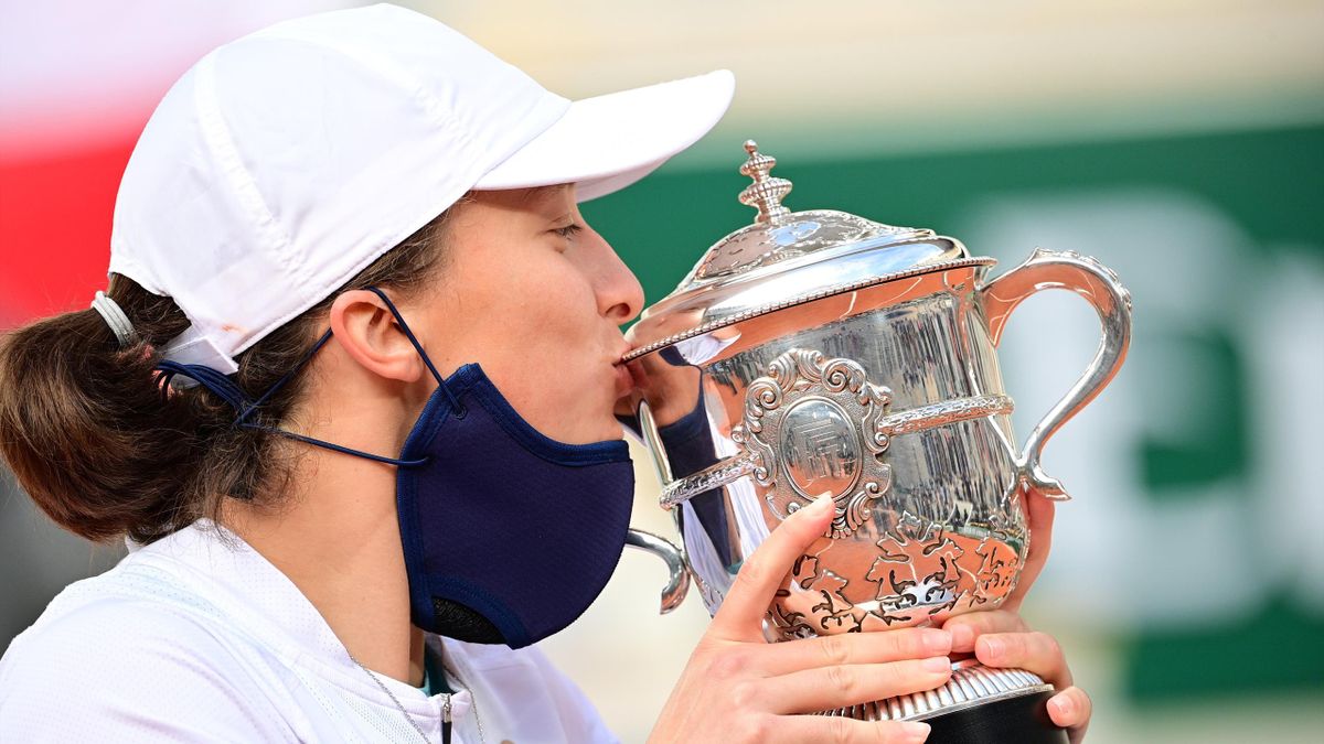 Poland's Iga Swiatek kisses and celebrates with the Suzanne Lenglen trophy during the podium ceremony after winning the women's singles final tennis match against Sofia Kenin of the US, at the Philippe Chatrier court, on Day 14 of Roland Garros 2020