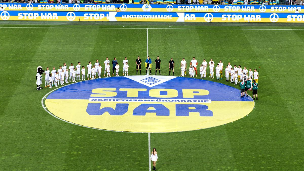 The teams of Borussia Moenchengladbach and Ukraine are standing in front of a stop war banner during a Charity match between Borussia Moenchengladbach and Ukraine at Borussia-Park on May 11, 2022 in Moenchengladbach, Germany