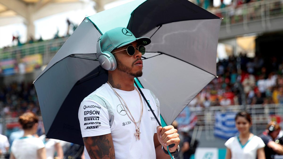 Mercedes' Lewis Hamilton of Britain holds an umbrella during the drivers parade
