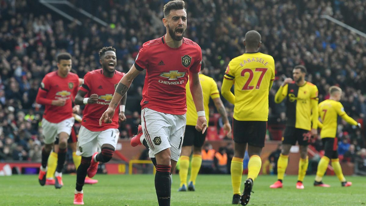Manchester United's Portuguese midfielder Bruno Fernandes (C) celebrates scoring the opening goal from the penalty spot during the English Premier League football match between Manchester United and Watford at Old Trafford