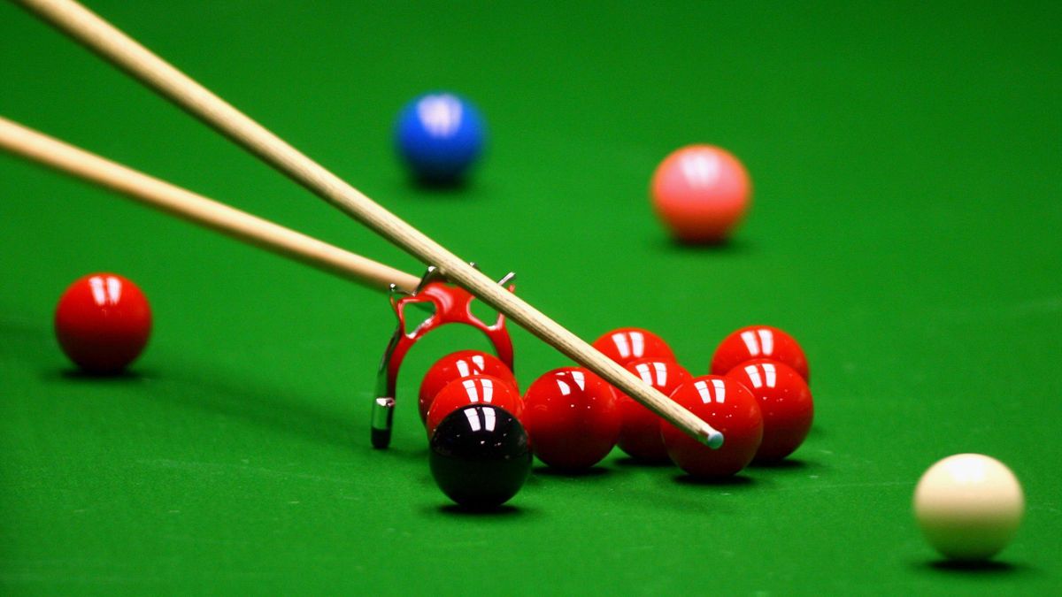 A generic snooker view of the white ball being struck by the cue using the bridge