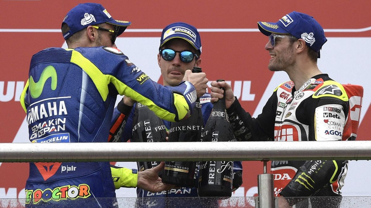 The winner, Yamaha Spanish biker Maverick Vinales (C), 2nd placed --also from Yamaha--Italian Valentino Rossi (L) and 3rd placed Honda biker Cal Crutchlow from the UK celebrate on the podium of the MotoGP race