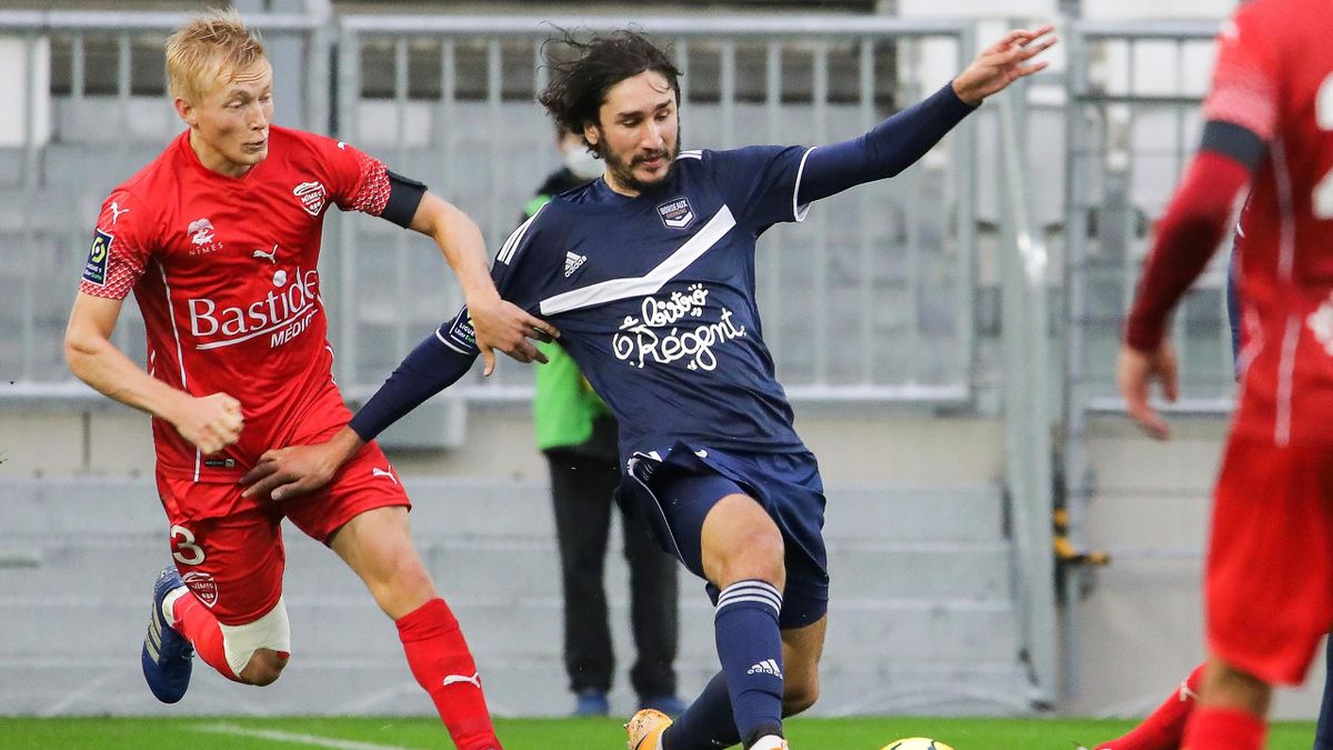 Nimes' Norwegian defender Birger Meling (L) vies for the ball with Bordeaux's French midfielder Yacine Adli during the French L1 football match between Bordeaux (FCGB) and Nimes (NO) on October 25, 2020, at the Matmut Atlantique Stadium in Bordeaux, south