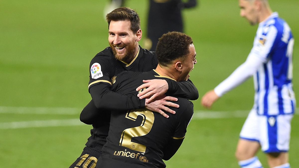 Barcelona's Barcelona's US defender Sergino Dest celebrates with Barcelona's Argentinian forward Lionel Messi (back) after scoring a goal during the Spanish League football match between Real Sociedad and Barcelona